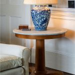Fosbury Table A beautifully hand-crafted piece, the Fosbury Table blends marble and wood in a timeless French-inspired design. The Carrara marble top, detailed with a subtle grooved edge, adds understated elegance, while the central tapered column and tripod pedestal base recall the refined proportions of classic Empire style. Ideal as a statement table in a living or dining space, it balances form and function with effortless sophistication. Dimensions H 69 cm Ø 79 cm Weight 41 kg Materials Beech and Carrara marble